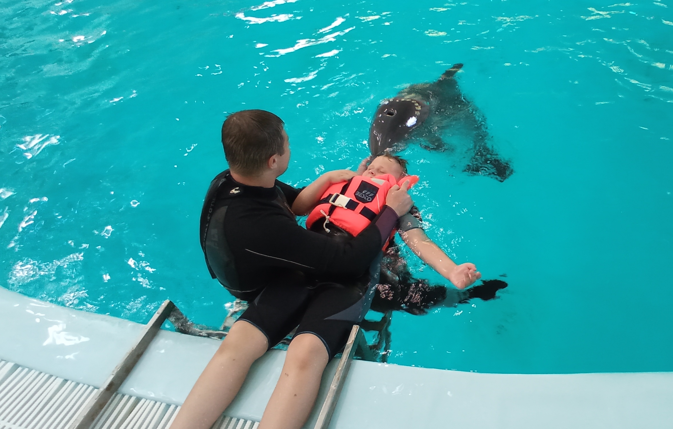 Delfínoterapia chlapca, ktorému pomáha dospelý